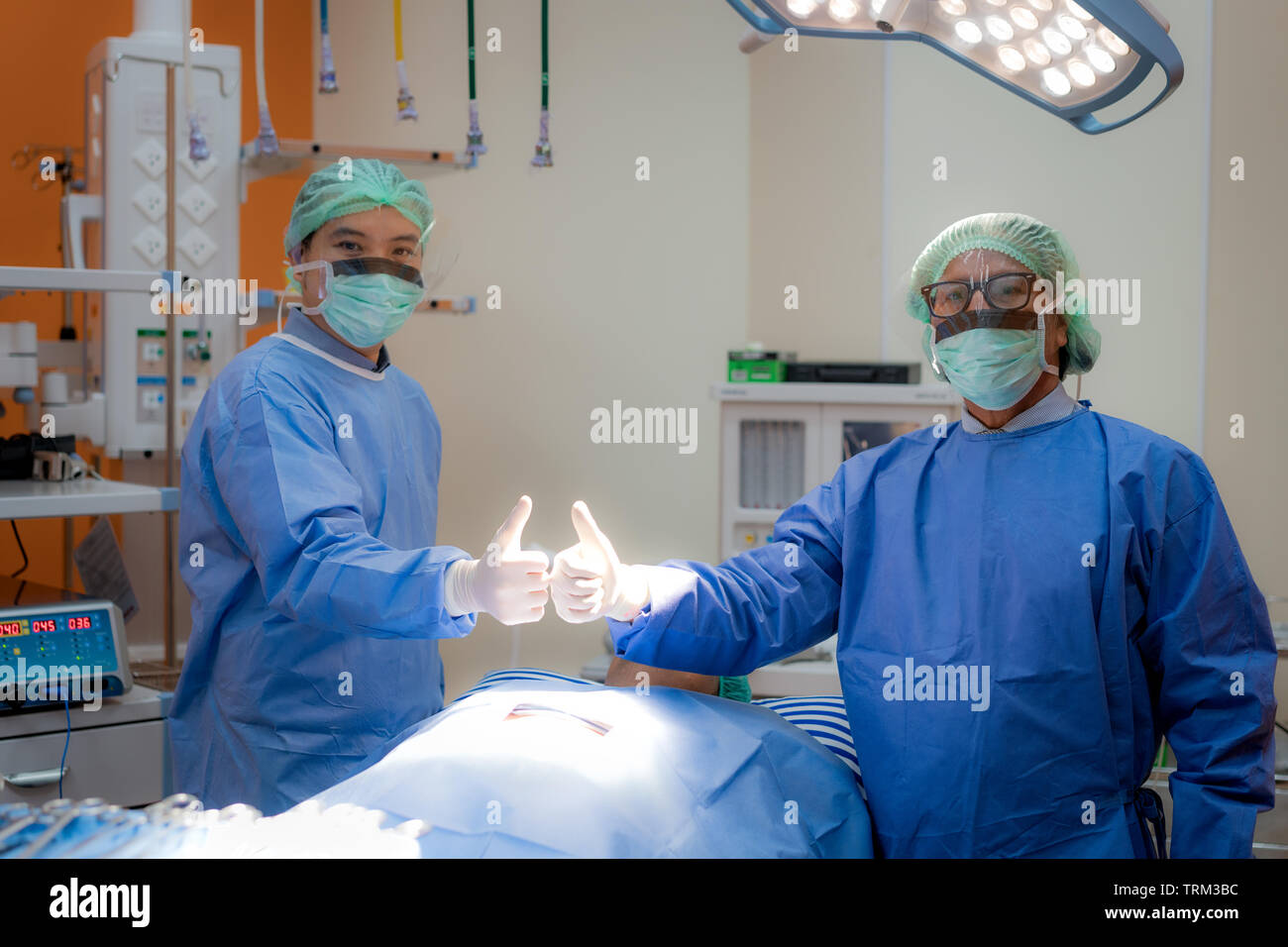 I chirurghi team cresciuto in uniforme e maschera visualizza thump fino in sala operatoria. Il team chirurgico la preparazione per la chirurgia in funzione. Foto Stock