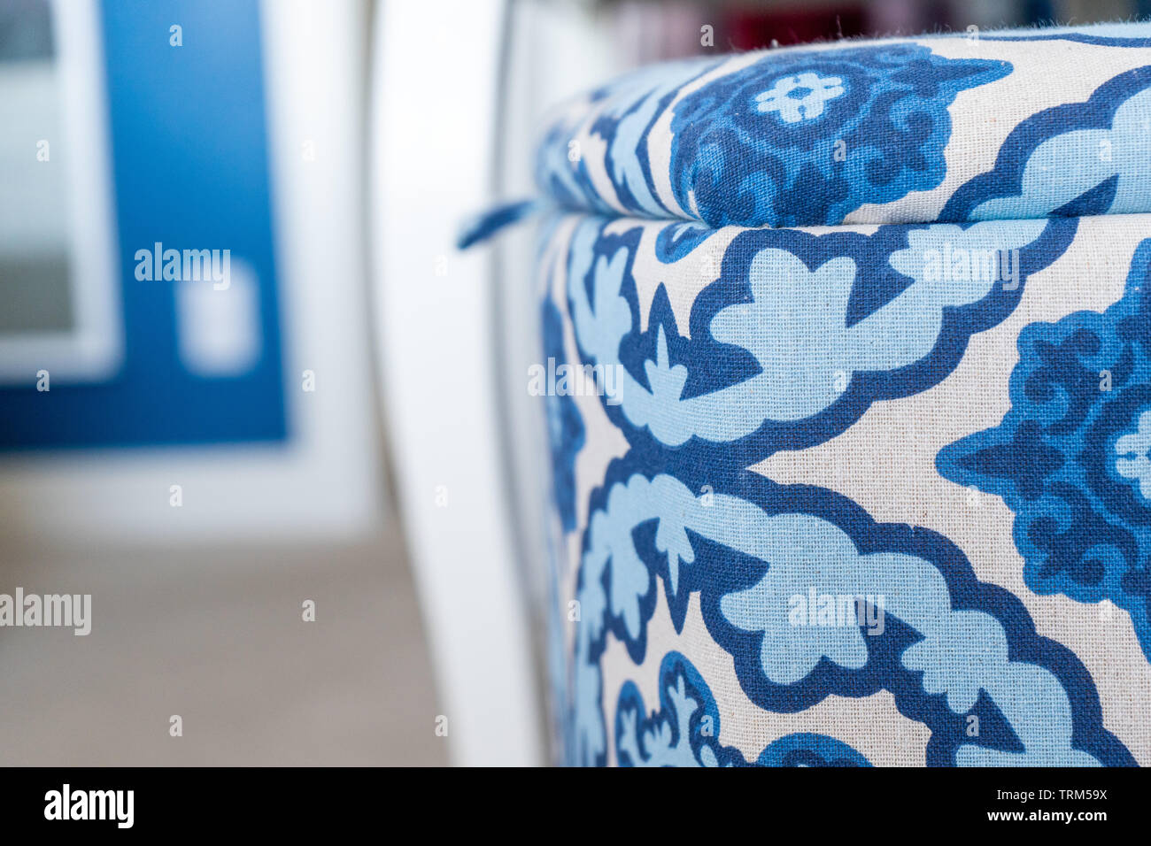 Close up di un blu e tessuto bianco cesto per la biancheria (una decorativa vano portaoggetti con un coperchio), in una camera da letto con il blu e il bianco degli arredi interni. Foto Stock