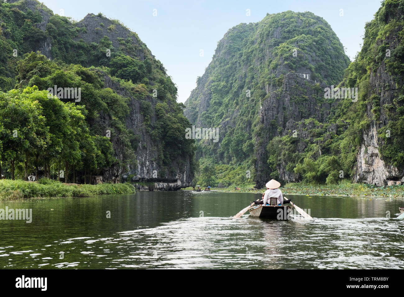 Attività a valle sulla barca con il vietnamita con piedi racchetta e vista montagna calcarea in Ngo Dong river, Ninh Binh, Halong Bay a terra Foto Stock