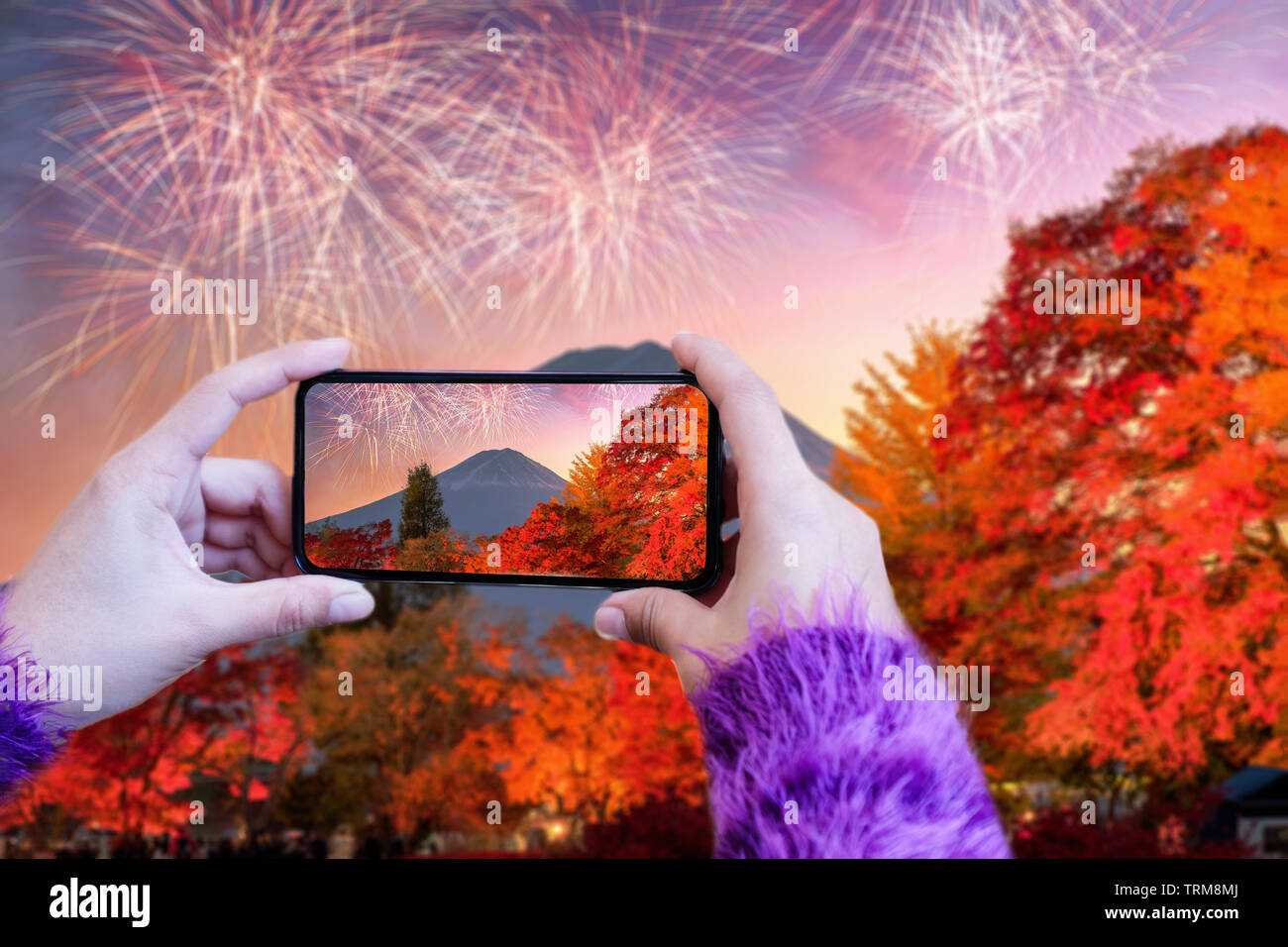 Mano azienda smart phone scattare una foto del Monte Fuji e fuochi d'artificio celebrazione Foto Stock