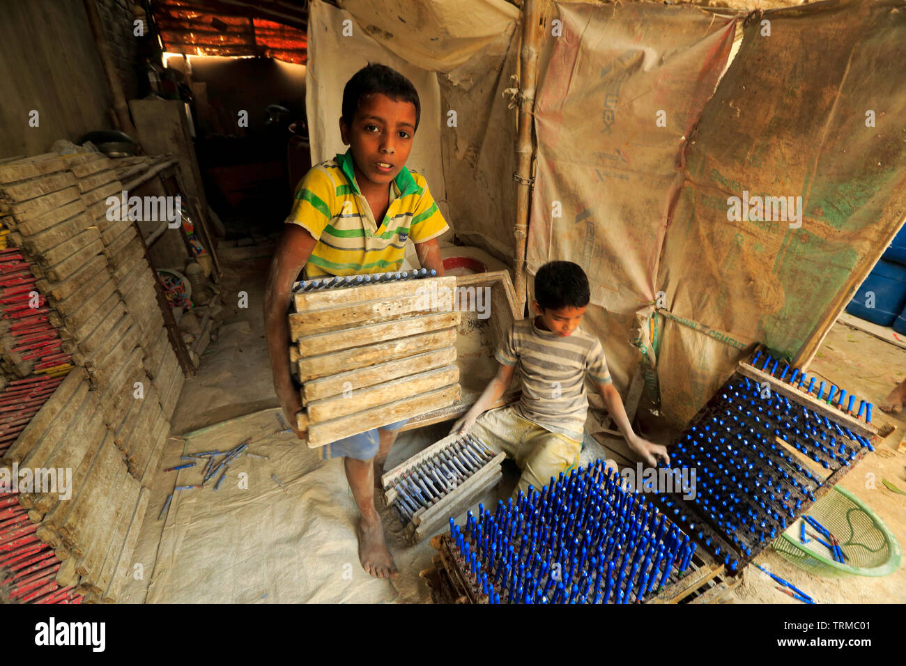 Un bambino lavora presso la fabbrica di palloncini a Kamrangirchar nella periferia di Dhaka, Bangladesh. Foto Stock