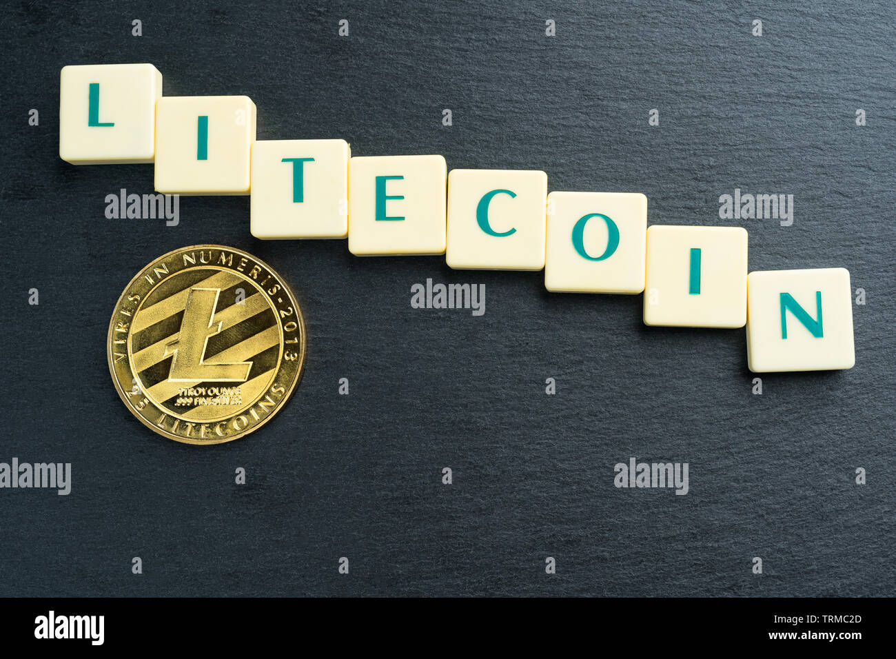 Litecoin fisico moneta in oro con testo realizzati al di fuori della lettera di piastrelle. Cryptocurrency rifiuta o recare mercato. Spazio di copia sul fondo superiore. Foto Stock
