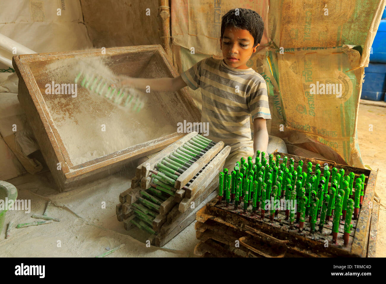 Un bambino lavora presso la fabbrica di palloncini a Kamrangirchar nella periferia di Dhaka, Bangladesh. Foto Stock