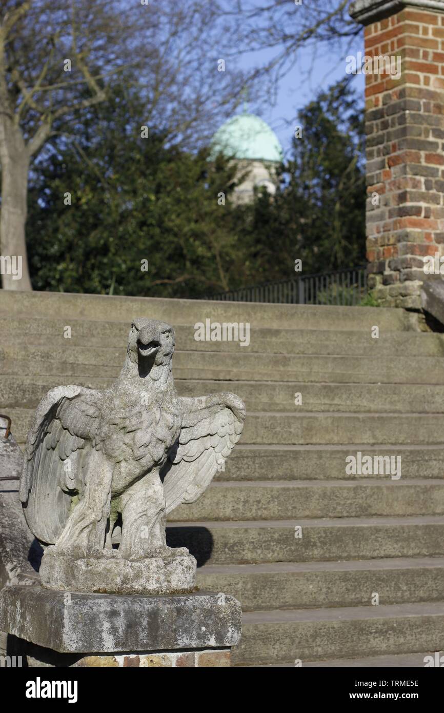 Immagine che mostra una scultura in pietra di un avvoltoio o eagle situato sul fondo di una scalinata in pietra con cupola di una chiesa in background Foto Stock