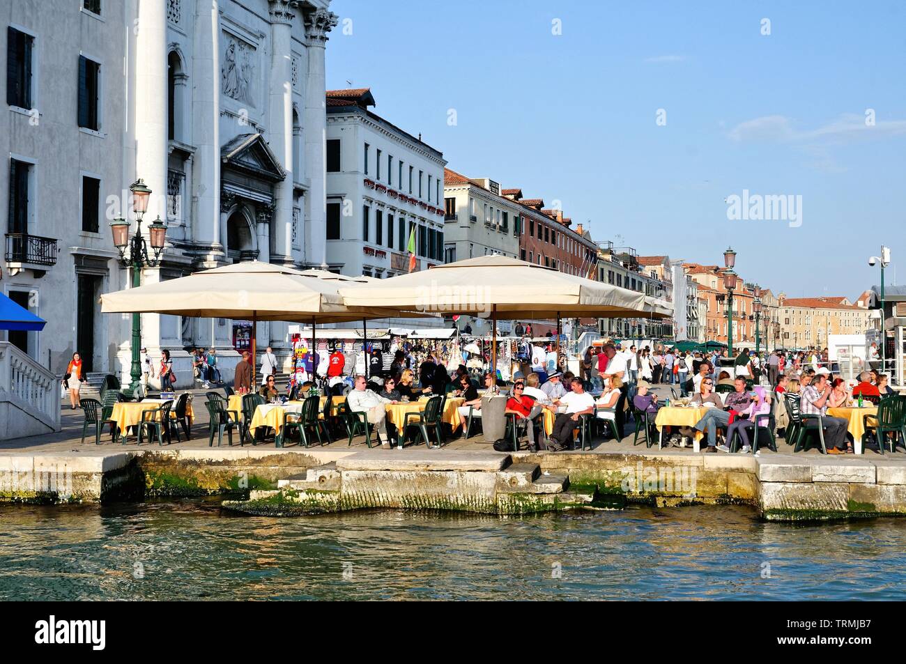 Outdoor diners sulla Riva degli Schiavoni waterfront godendo di una serata estati, Venezia Italia Europa UE Foto Stock