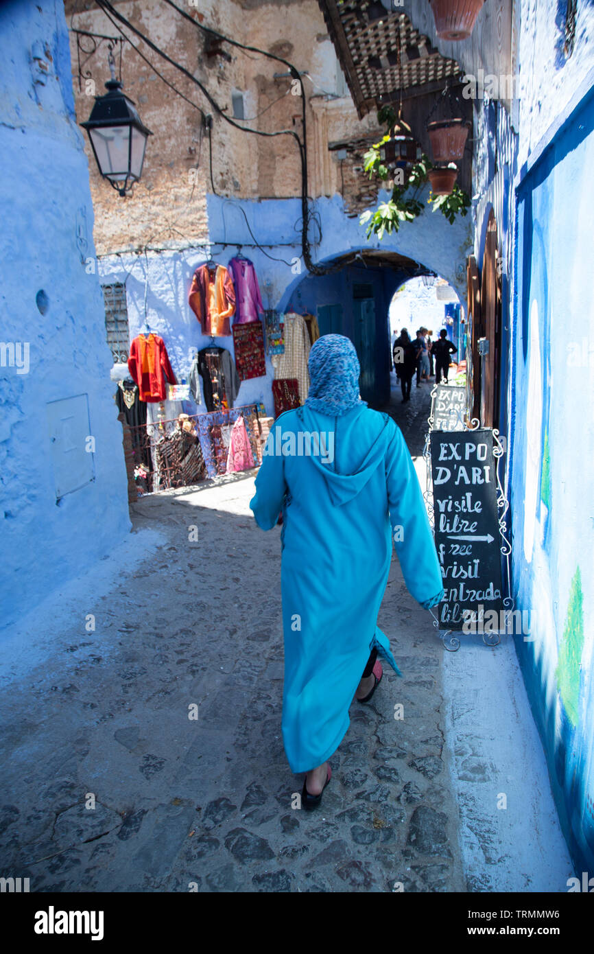 Donna che cammina nella città blu di Chefchaouen, Marocco Foto Stock