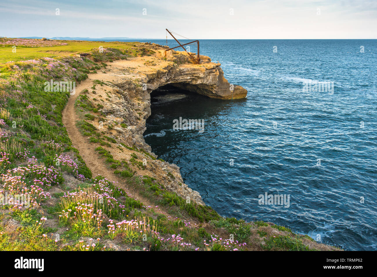 In disuso illuminazione cava gru o paranco sopra un mare grotta presso Portland Bill sulla isola di Portland, Jurassic Coast di Dorset, Inghilterra, Regno Unito. Foto Stock