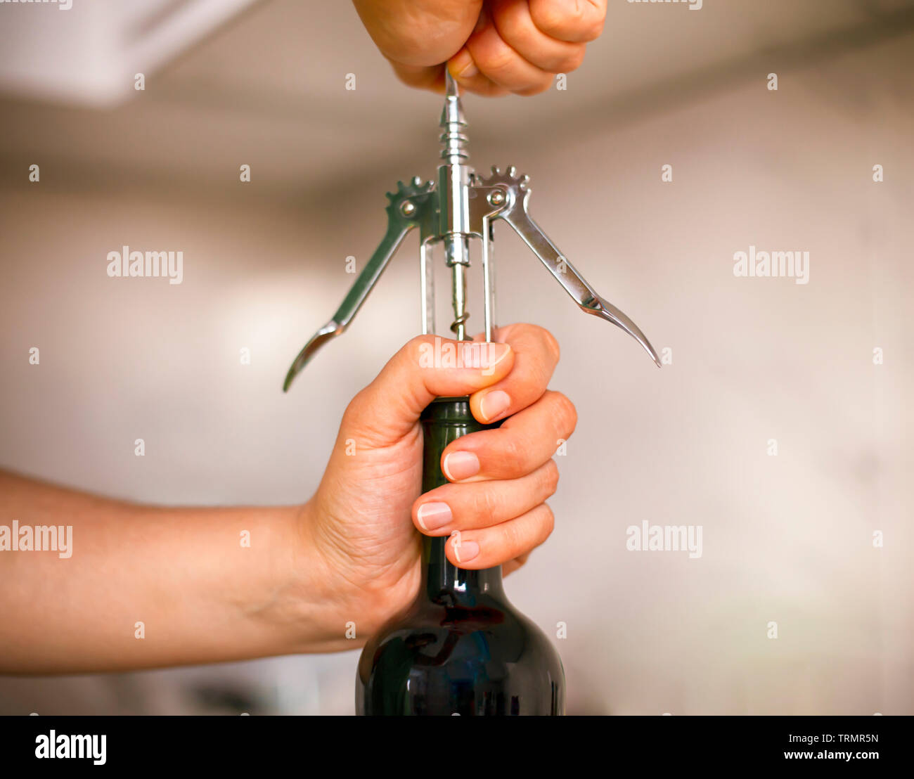 Donna di aprire una bottiglia di vino con un cavatappi. Close-up Foto stock  - Alamy