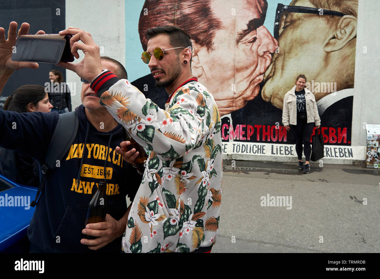 Nella East Side Gallery, due amici fanno un selfie di fronte alla ricreazione sul muro del bacio tra Erich Honecker e Leonidas Brezhnev. Foto Stock