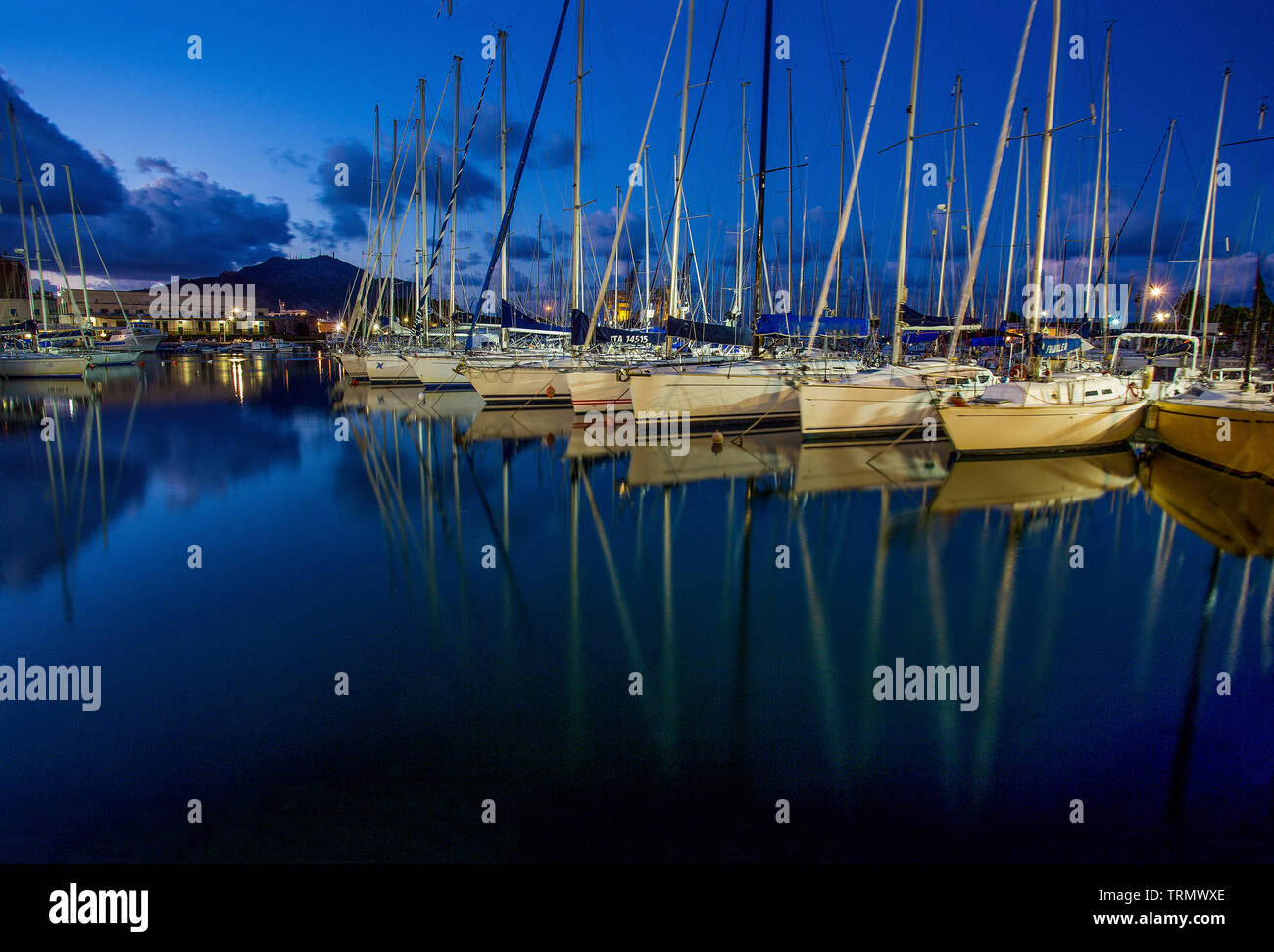 Sera - yacht ormeggiati nel porto di Palermo. Luci della Citta'. Blue skay e acqua Foto Stock