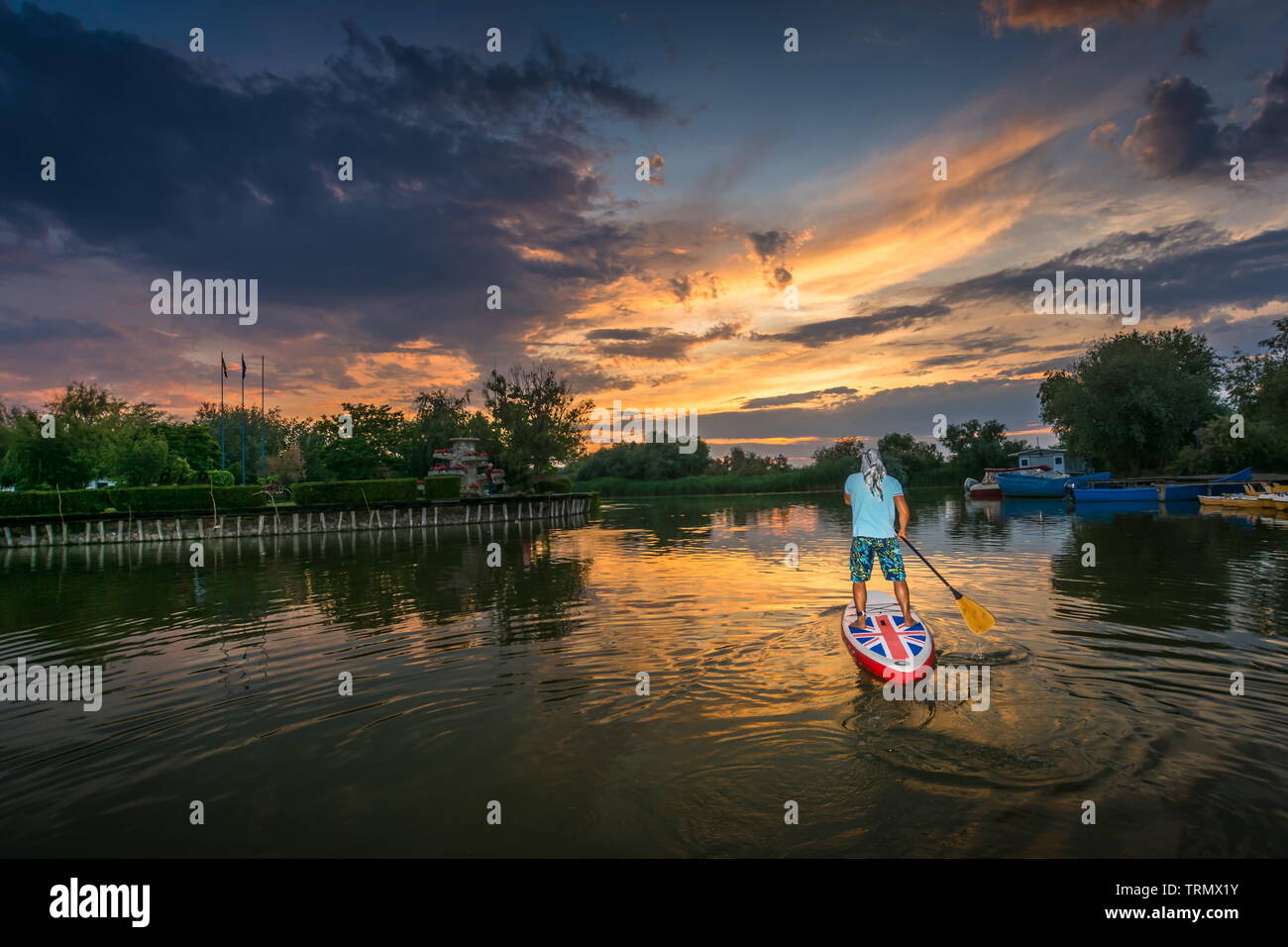 Gura Portitei, Romania - 08 Giugno 2019: l'uomo sul SUP board, stand up paddling al tramonto sul lago nel Delta del Danubio a Gura Portitei, Romania Foto Stock