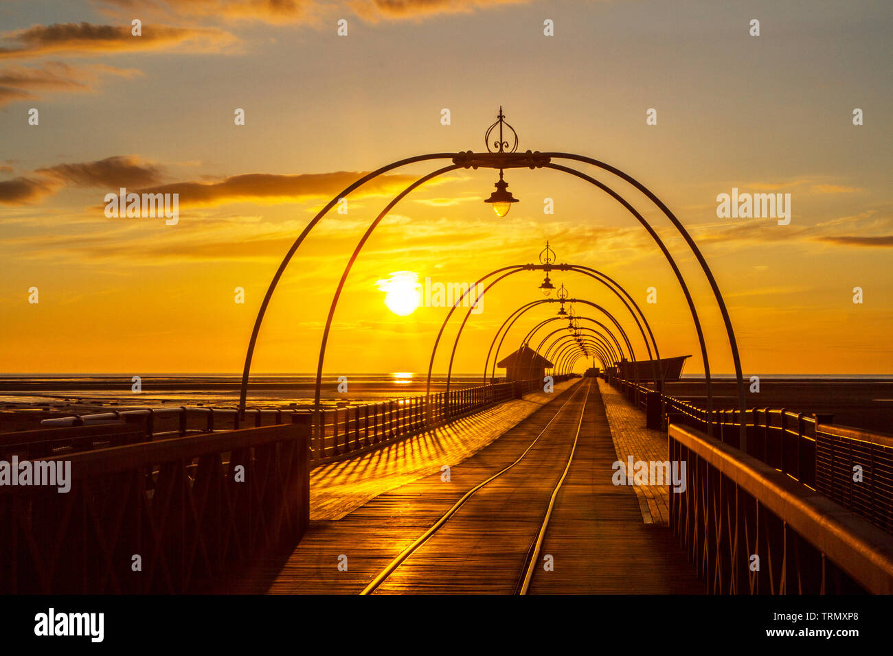 Southport, Merseyside, Regno Unito. Il 9 giugno 2019. Un bel tramonto si accoccola in letto dietro gli archi che attraversano il famoso molo a Southport nel Merseyside. Southport Pier è un piacere pier a Southport, Merseyside England. Inaugurato nel mese di agosto 1860, è il più antico molo di ferro nel paese. La sua lunghezza di 1.108 m rende la seconda più lunga in Gran Bretagna. Credito: Cernan Elias/Alamy Live News Foto Stock