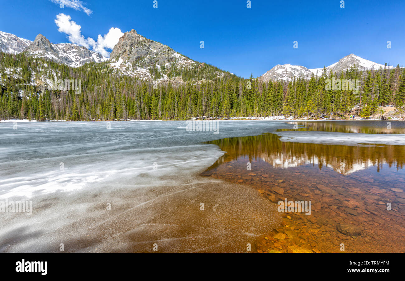 Piccolo Cervino e montagne Gabletop riflessa in parzialmente congelati Fern lago nel Parco Nazionale delle Montagne Rocciose, Estes Park, Colorado. Foto Stock