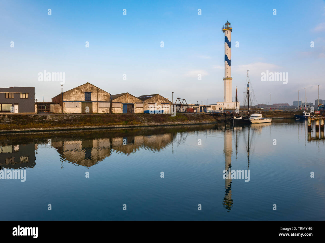 Il famoso faro di Ostenda in città con un riflesso in una delle banchine commerciali del porto, Fiandre Occidentali, Belgio. Foto Stock