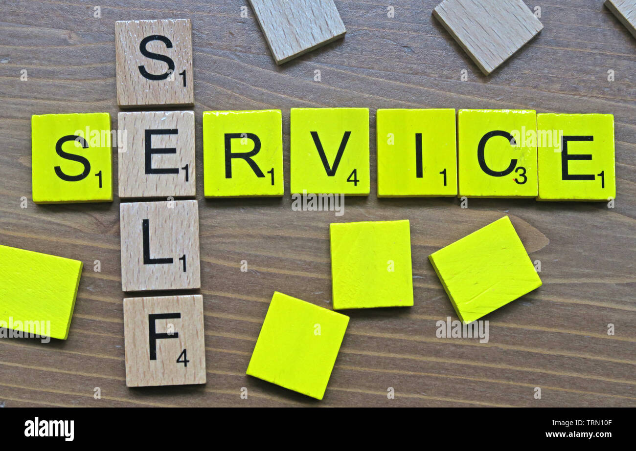 Self-Service - scritto in giallo e in legno Scrabble lettere Foto Stock
