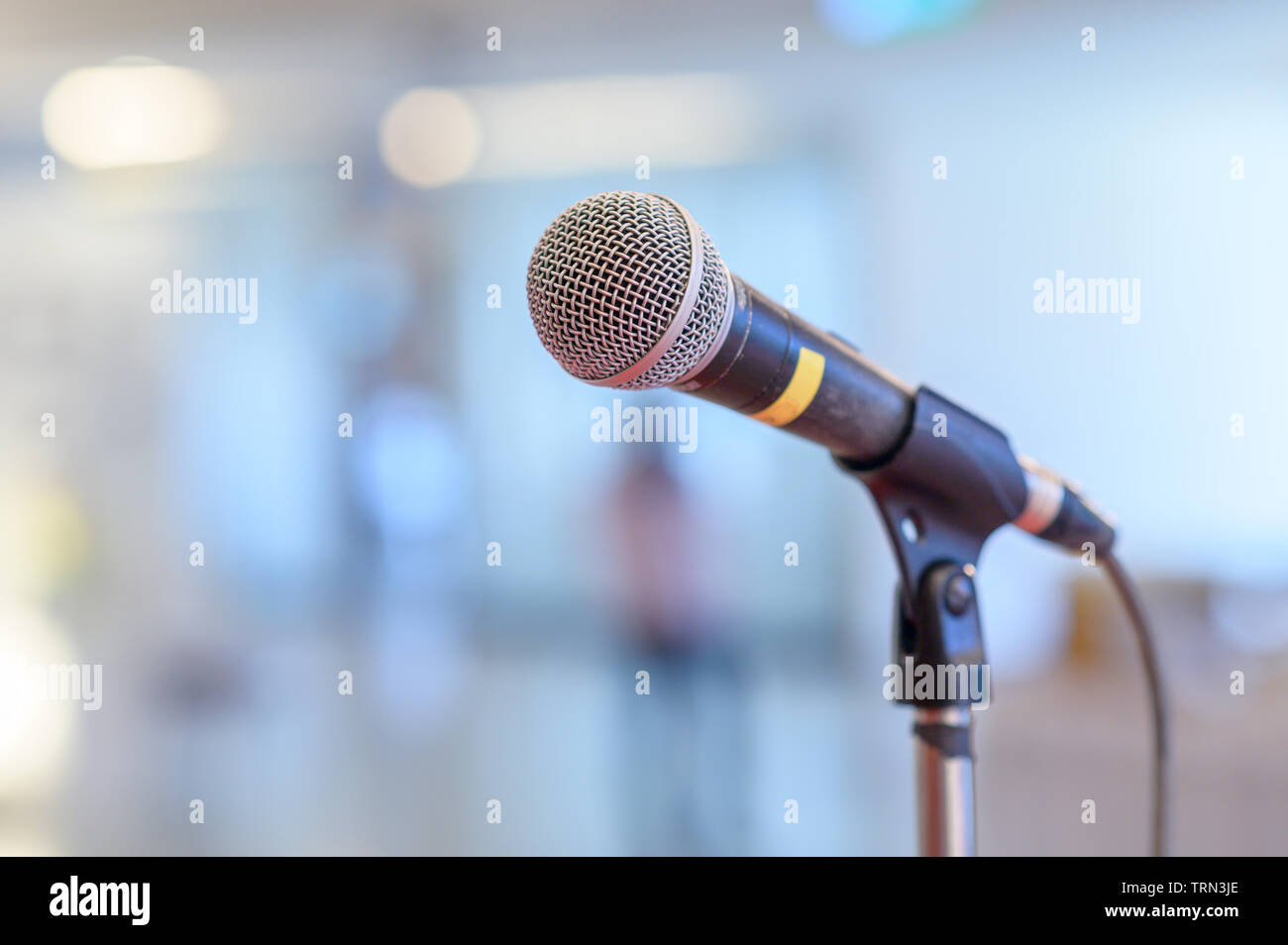 Microfono di comunicazione sul palco contro uno sfondo di auditorium stadio di concerto Foto Stock