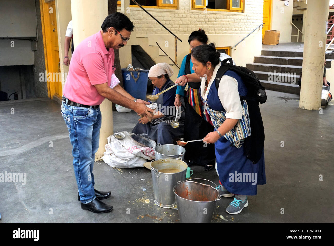 I volontari di incavature fuori i pasti gratuiti per i partecipanti a un corso di insegnamento al Dalai Lama Temple Foto Stock
