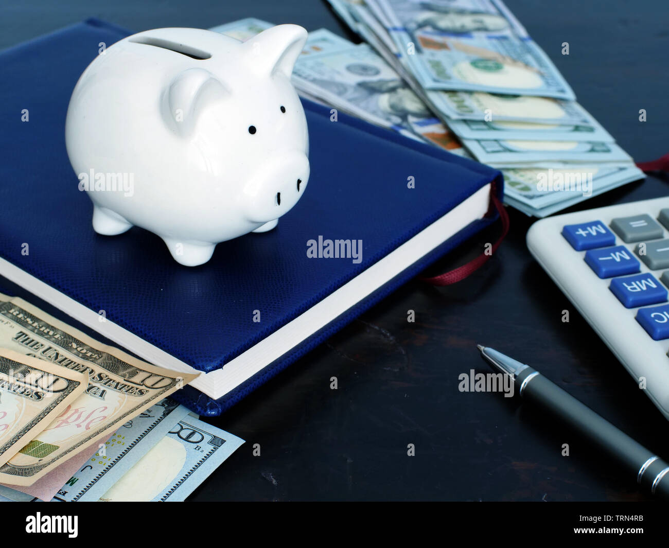 Risparmio di denaro concetto. Salvadanaio e contanti a casa. Foto Stock