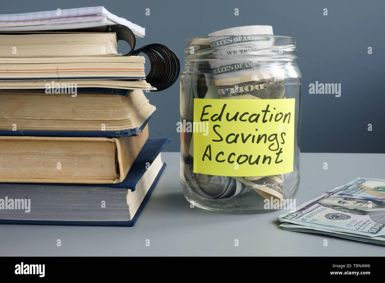ESA Istruzione conto risparmio etichetta sul vaso con denaro e libri. Foto Stock