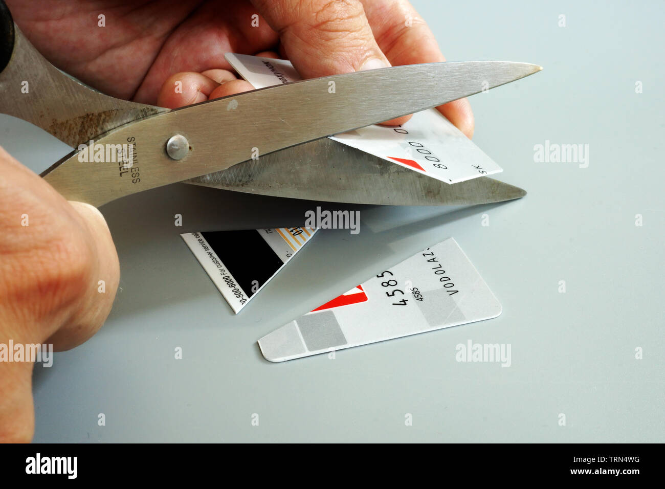 Uscire del debito della carta di credito. L uomo è il taglio di carta bancaria. Foto Stock