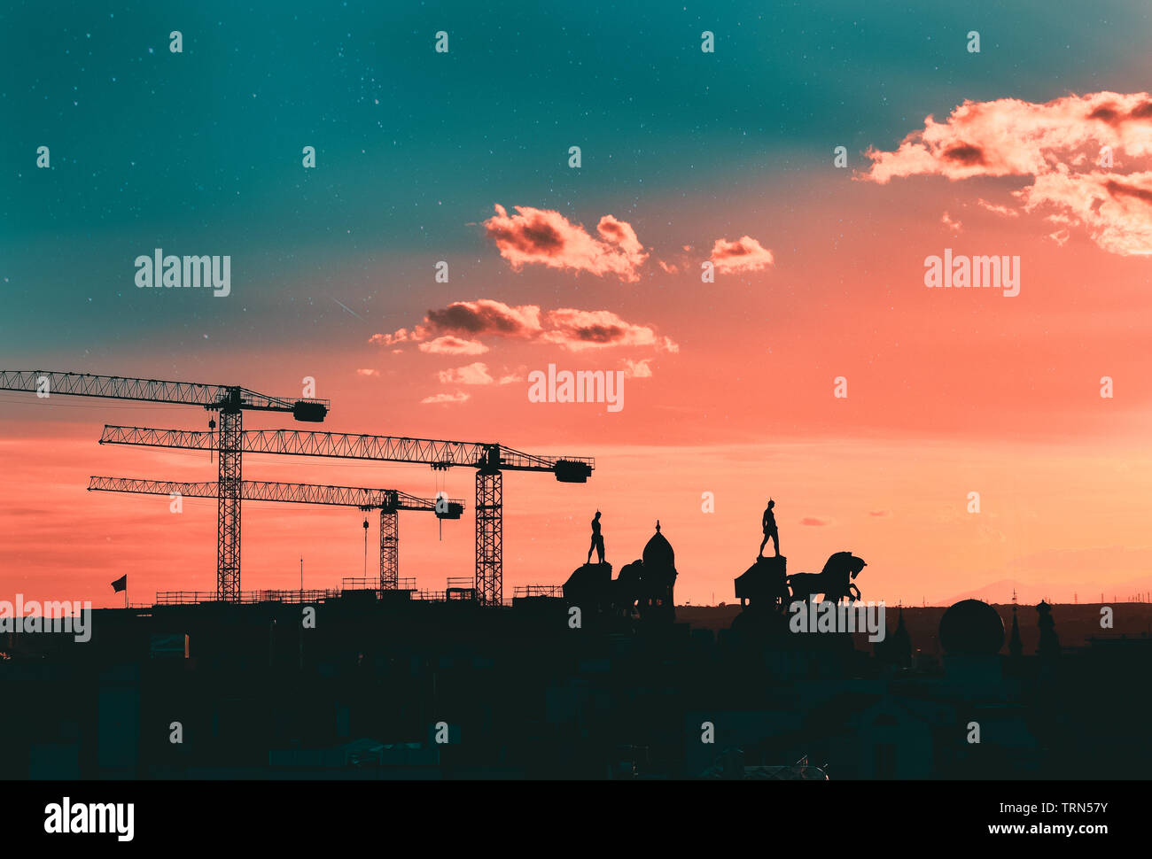 Sagome di gru, statue e edifici di Madrid, con un creative star sky di corallo e teal colore. Madrid, Spagna Foto Stock