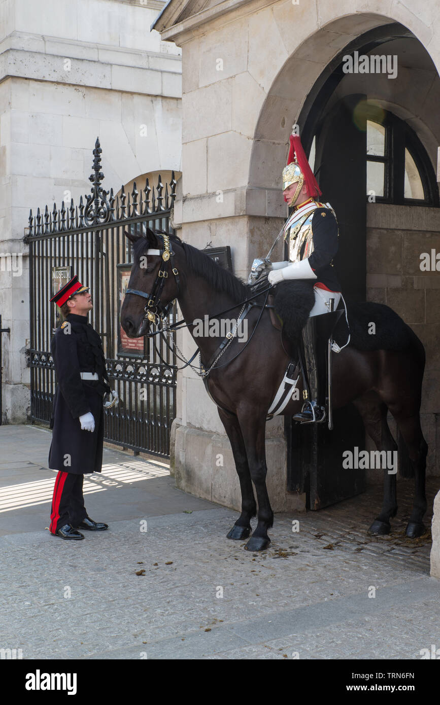 In Whitehall, è montato un soldato di cavalleria della famiglia parla con un funzionario. Foto Stock
