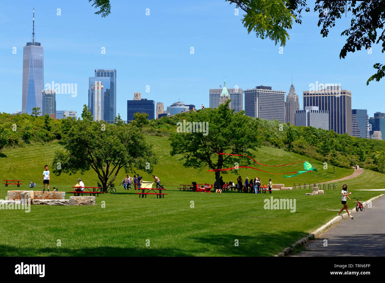 Governors Island Punto di picnic e colline con Downtown skyline di Manhattan in background Foto Stock