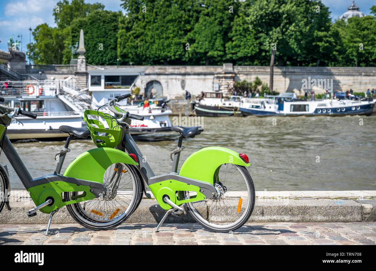 Via Parigi trasporto ibrido verde noleggio biciclette con modulo elettronico di pagamento per i viaggi in giro per la città di stand sulle rive della Senna w Foto Stock