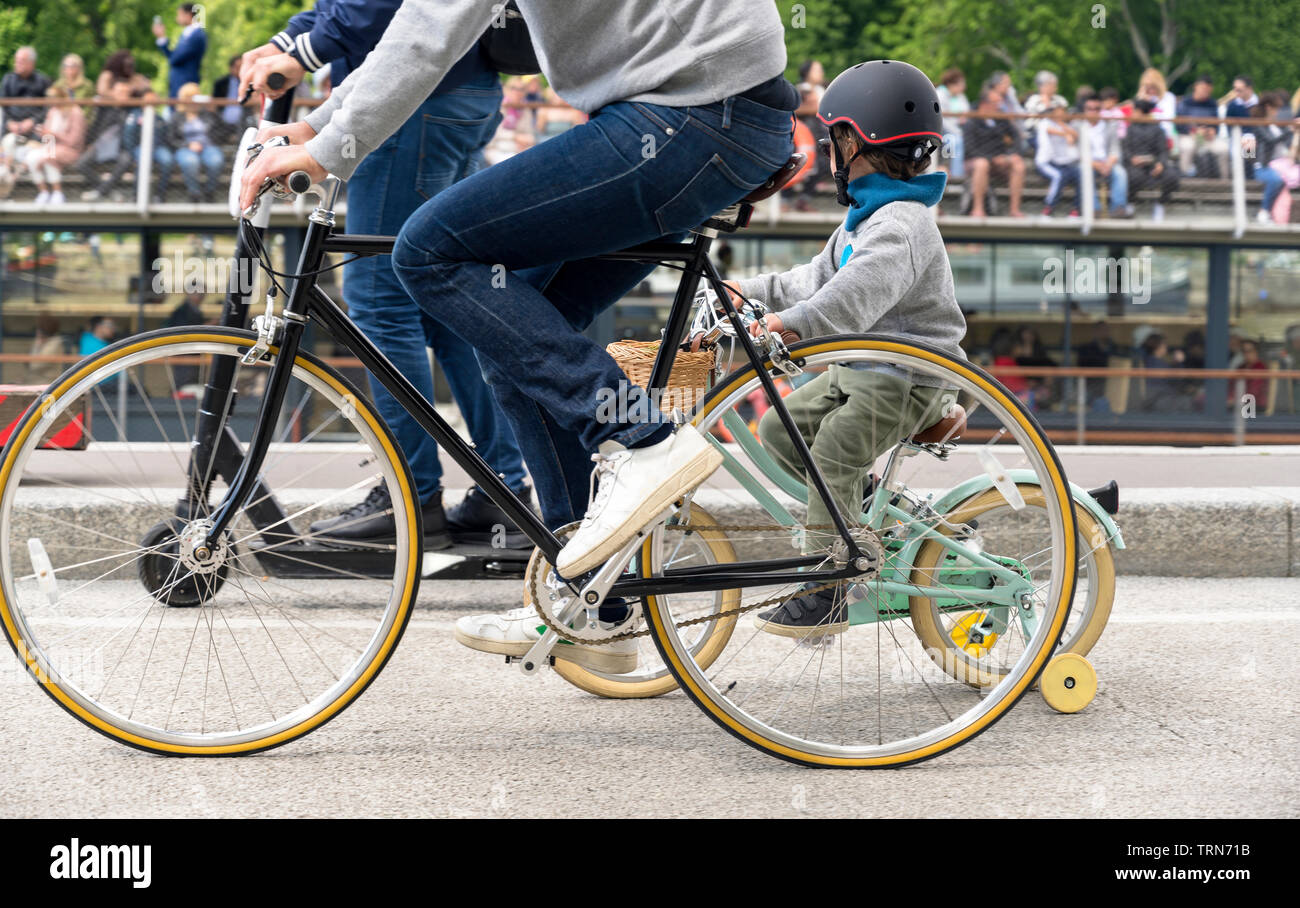 Una famiglia su una bicicletta pedali di una bici, preferendo attivo un sano stile di vita utilizzando il ciclismo e l'alternativa ecocompatibile modalità di trasporto Foto Stock