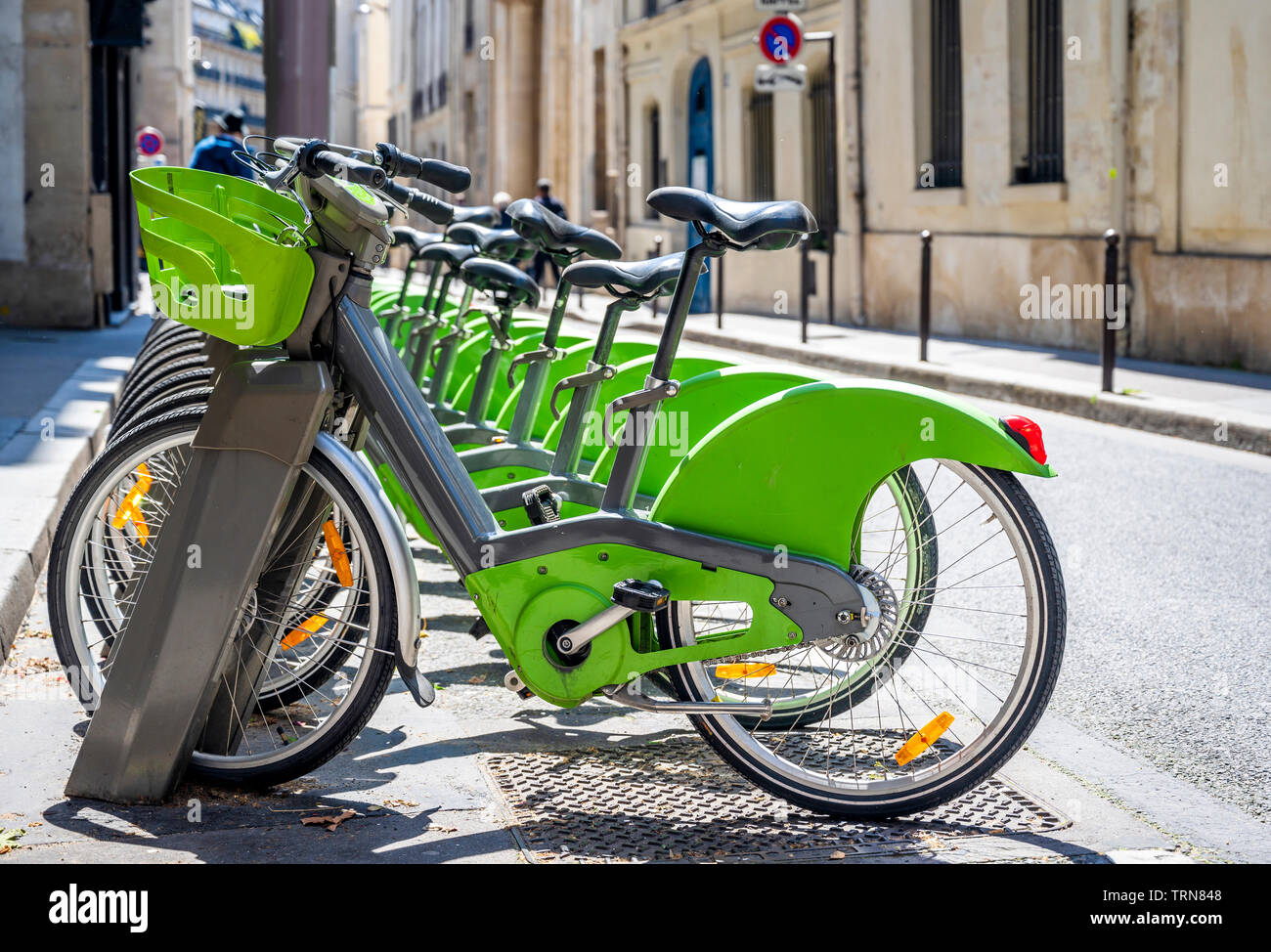 Via Parigi trasporto ibrido verde noleggio biciclette con modulo elettronico di pagamento per i viaggi in giro per la città di stand in fila sulla rete di noleggio pa Foto Stock