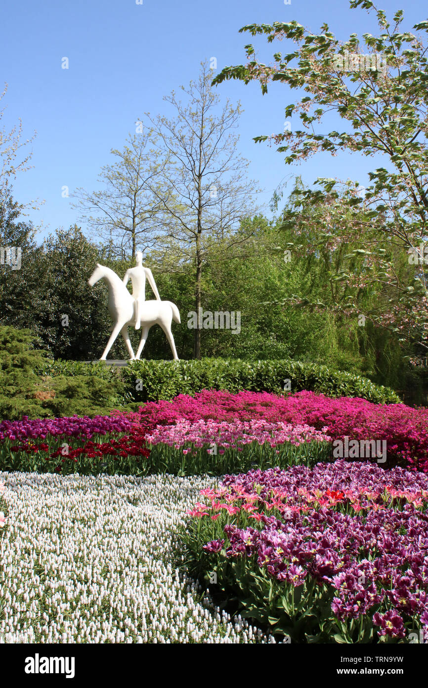 White scultura di un uomo a cavallo nel display floreale in giardini Keukenhof vicino a Lisse in South Holland, Paesi Bassi su una soleggiata giornata di primavera nel 2019. Foto Stock