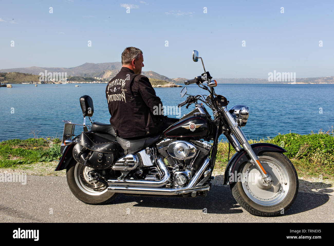 Uomo in giacca di pelle su una Harley Davidson Moto per il mare di Creta Grecia Foto Stock