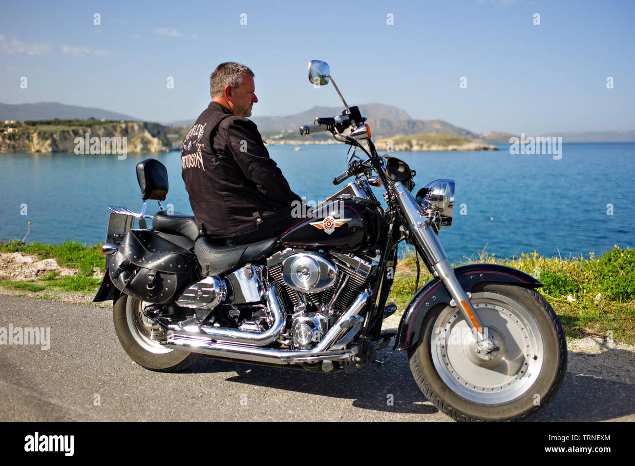 Uomo in giacca di pelle su una Harley Davidson Moto per il mare di Creta Grecia Foto Stock