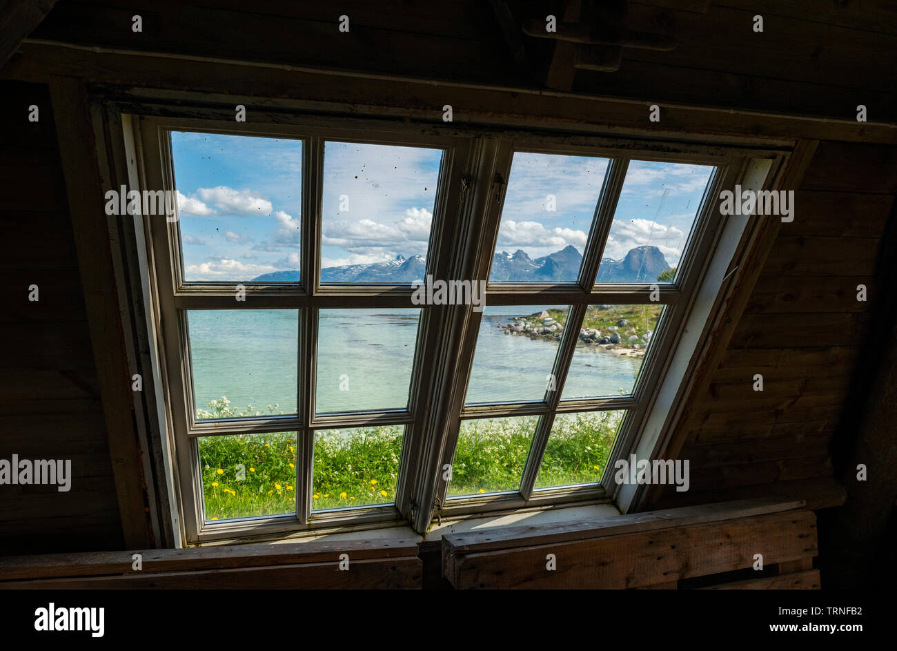 Guardando attraverso la finestra verso le sette sorelle Mountain Range, Heroy Camping, Heroy Isola, Norvegia, estate 2019. Foto Stock