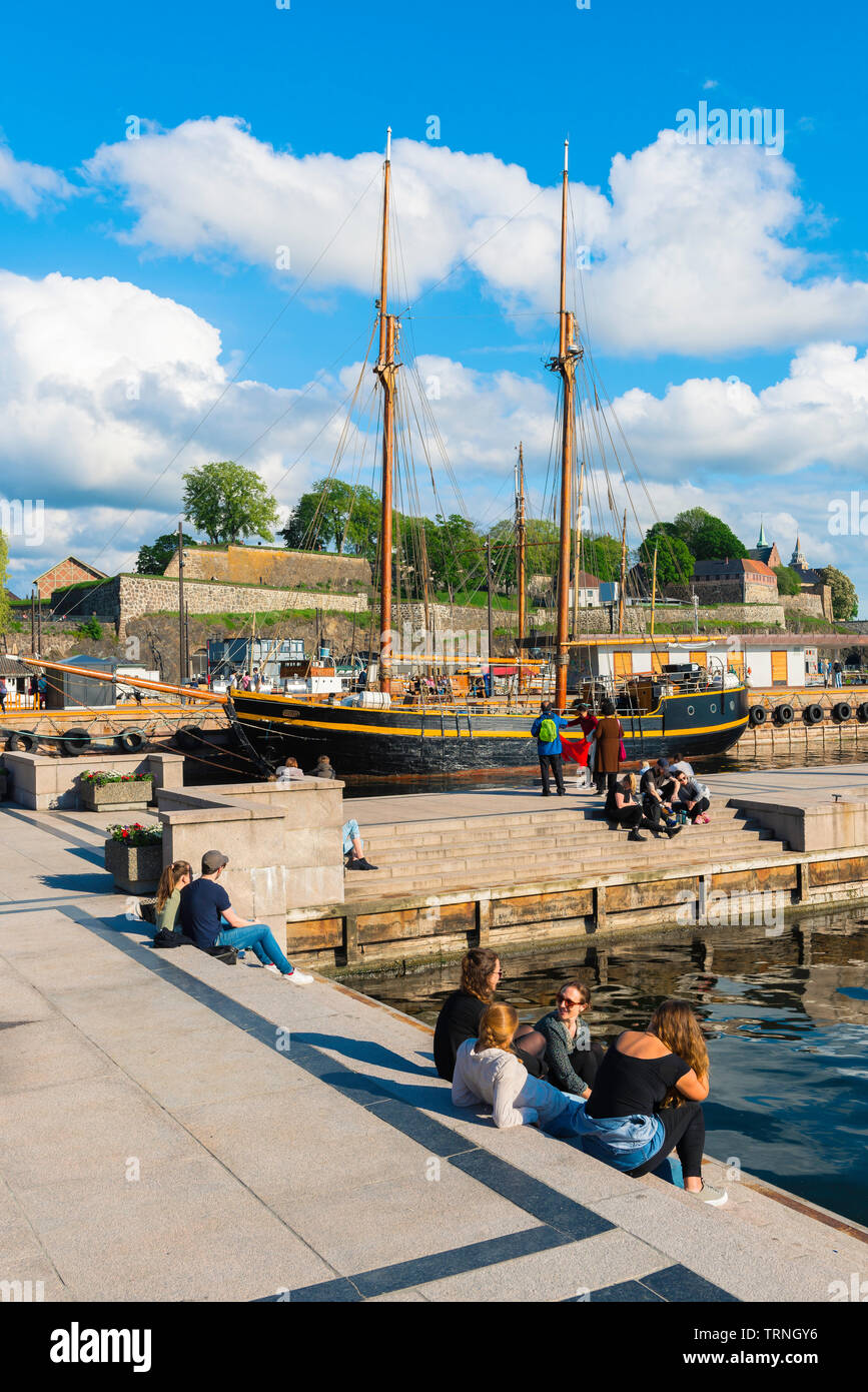 Porto di Oslo, vista di giovani rilassante accanto a una banchina del porto (Aker Brygge) di Oslo per un pomeriggio d'estate, Norvegia. Foto Stock