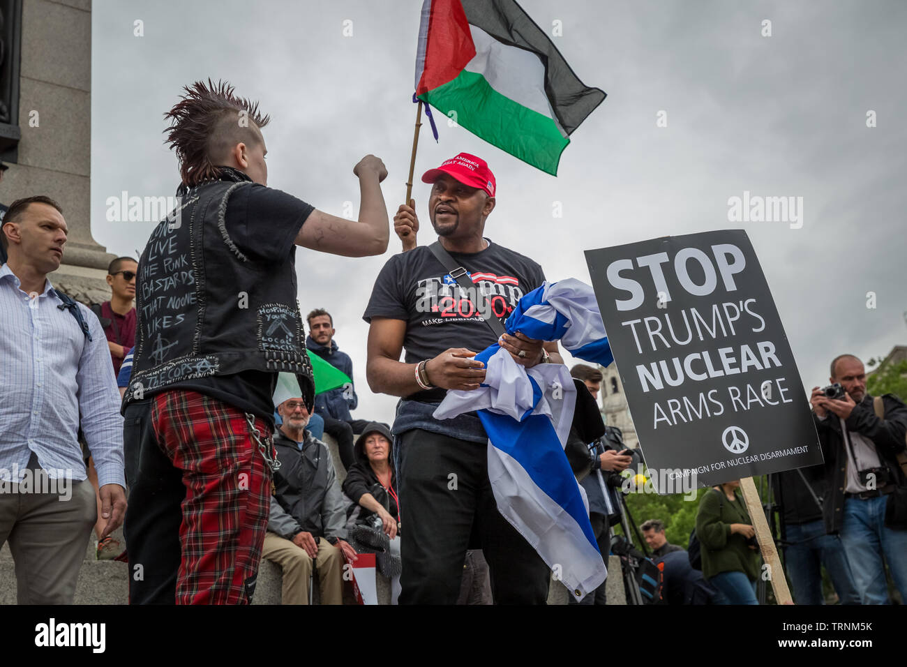 Un LGBT anti-Trump(L) attivista e un pro-Trump(C) sostenitore rabbiosamente dibattito in Trafalgar Square durante le proteste di massa contro il presidente statunitense Donald Trump's UK visita di stato. Foto Stock