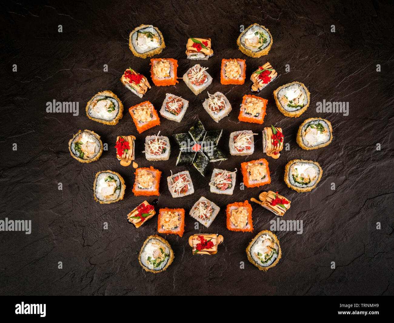 Un grande insieme di panini freschi in stile giapponese su uno sfondo scuro, vista dall'alto Foto Stock