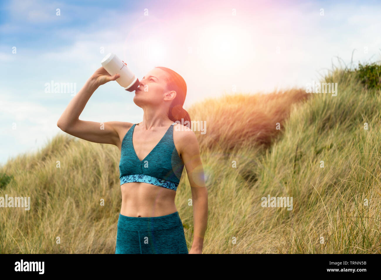 Sportive di bere acqua da una bottiglia dopo esercizio di Sun Foto Stock