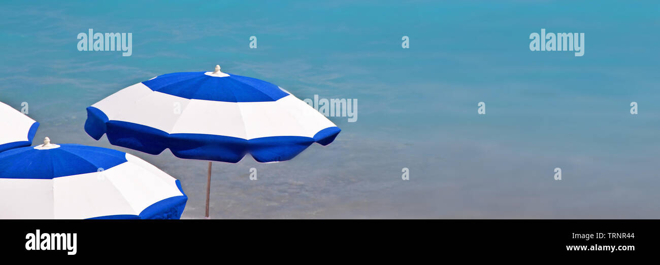 Ombrelloni da spiaggia, vista panoramica sull'oceano blu sullo sfondo Foto Stock