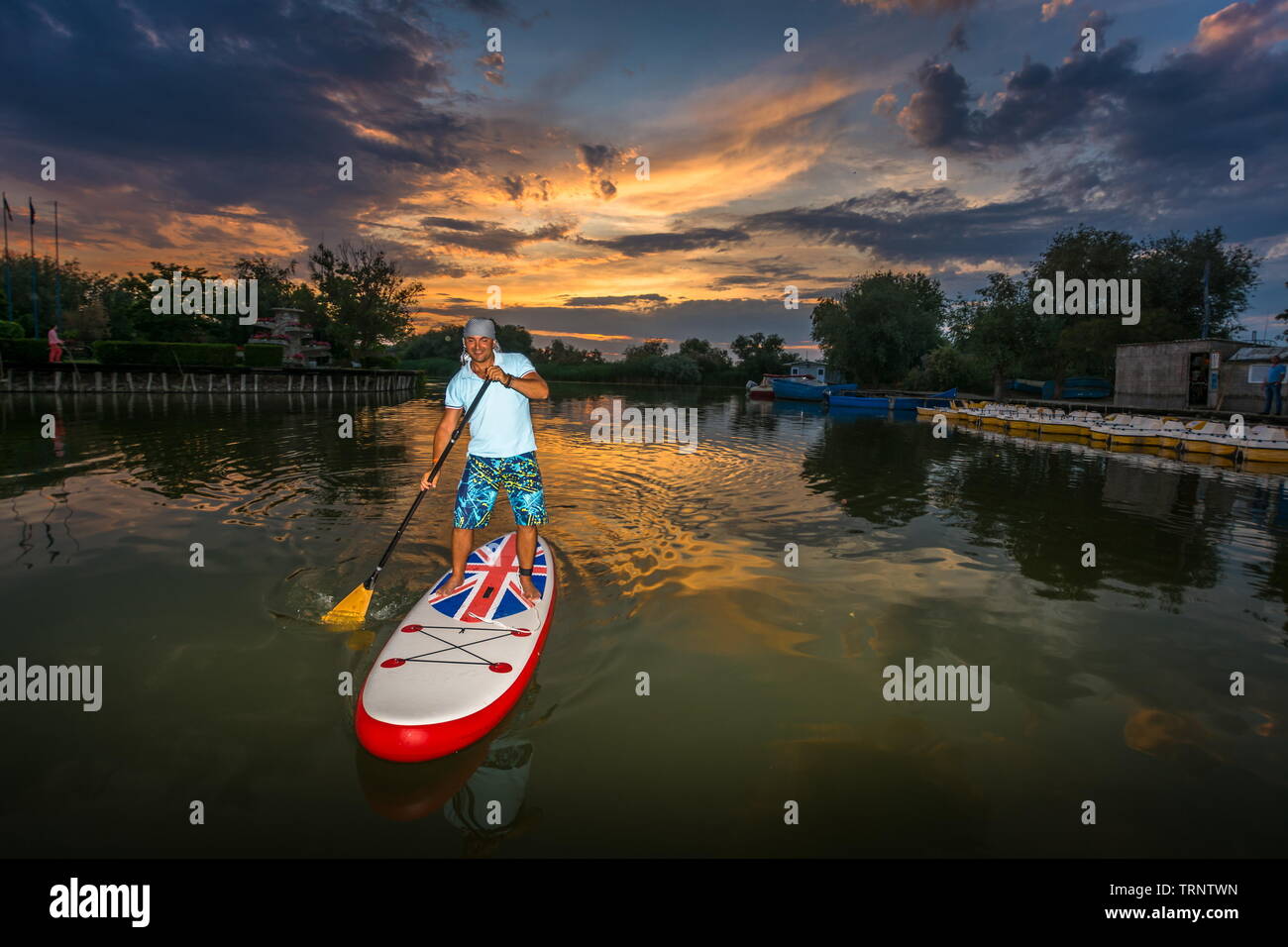 Gura Portitei, Romania - 08 Giugno 2019: l'uomo sul SUP board, stand up paddling al tramonto sul lago nel Delta del Danubio a Gura Portitei, Romania Foto Stock