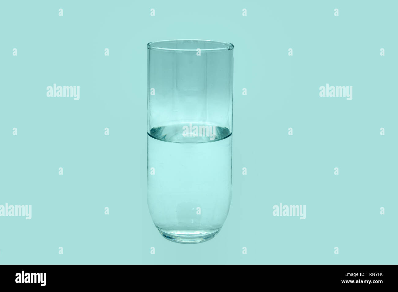 Mezzo bicchiere di acqua pura isolato su un background. Foto Stock