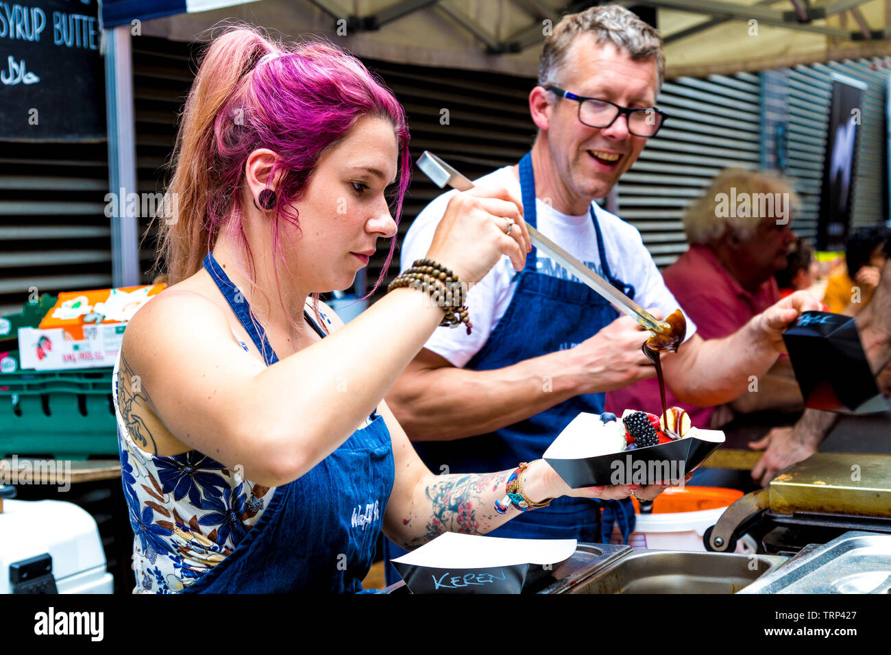 Donna che serve le cialde con condimenti alla Waffle su, Maltby Street Market, London, Regno Unito Foto Stock