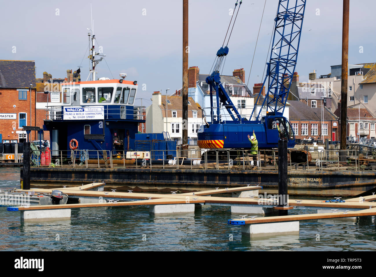 Un semoventi chiatta di palificazione si sposta in posizione di inserimento di palificate per lavori di costruzione a Weymouth Harbour. Foto Stock