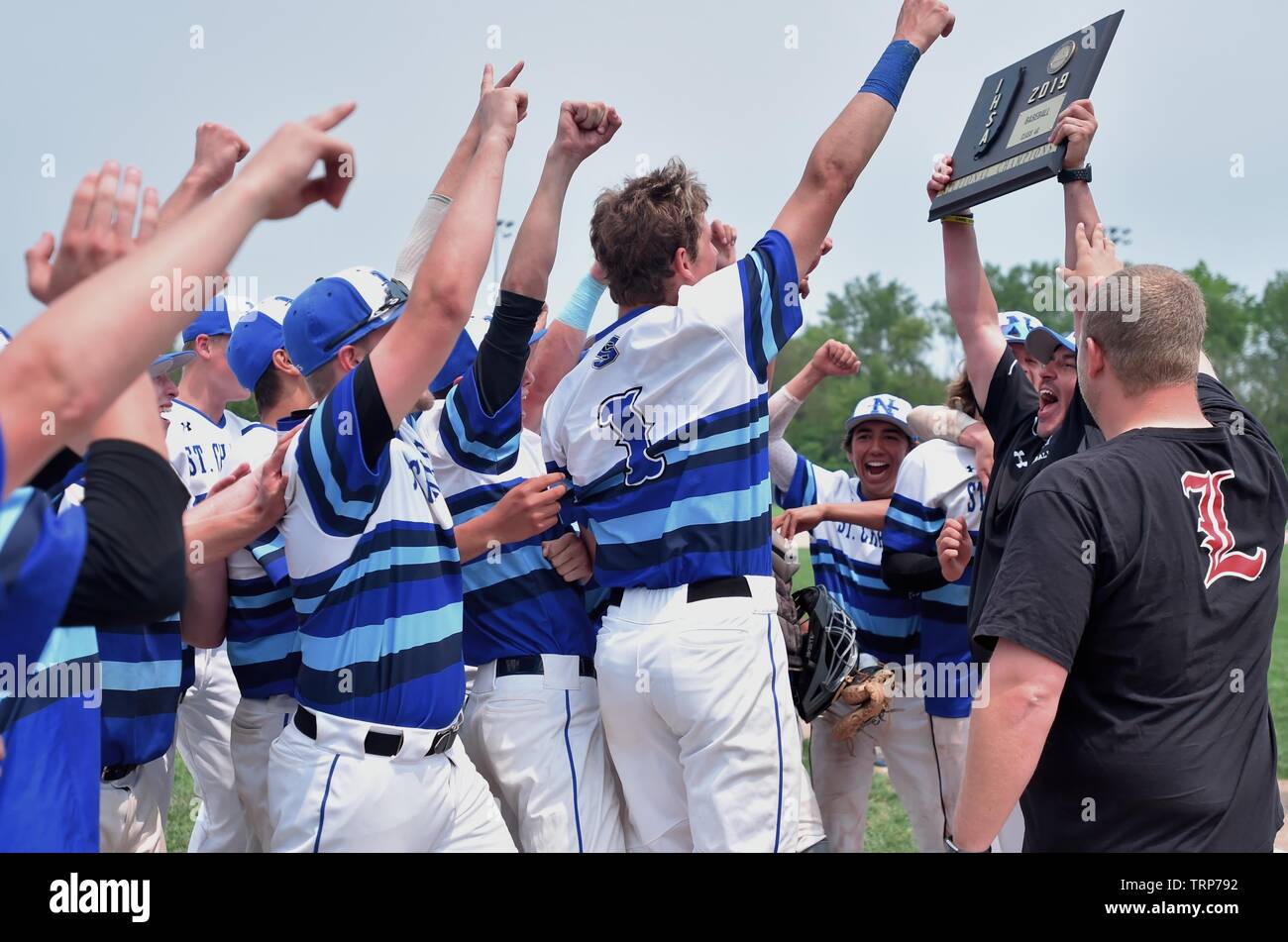 I giocatori celebrando intorno al loro allenatore che ha trionfalmente solleva una appena guadagnato il campionato di sezione trofeo sopra la sua testa. Stati Uniti d'America. Foto Stock