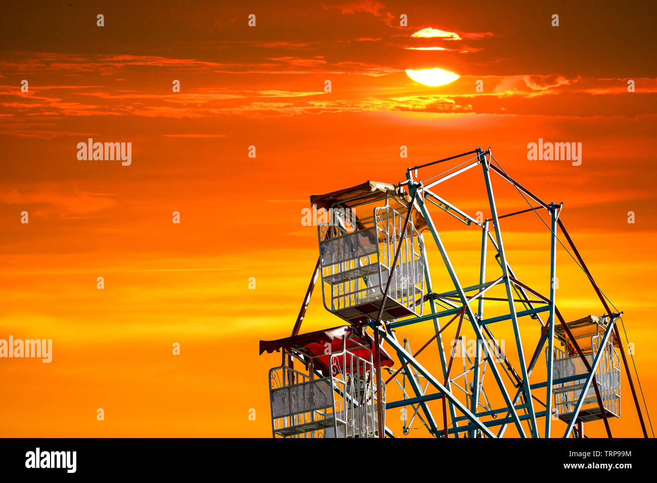 Ultima luce del tramonto su sky e silhouette ruota panoramica Ferris e il rosso il cloud su sky Foto Stock