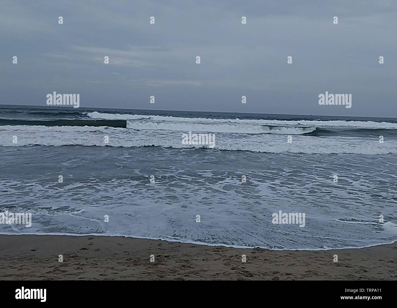 Le onde del mare di colpire la riva Foto Stock