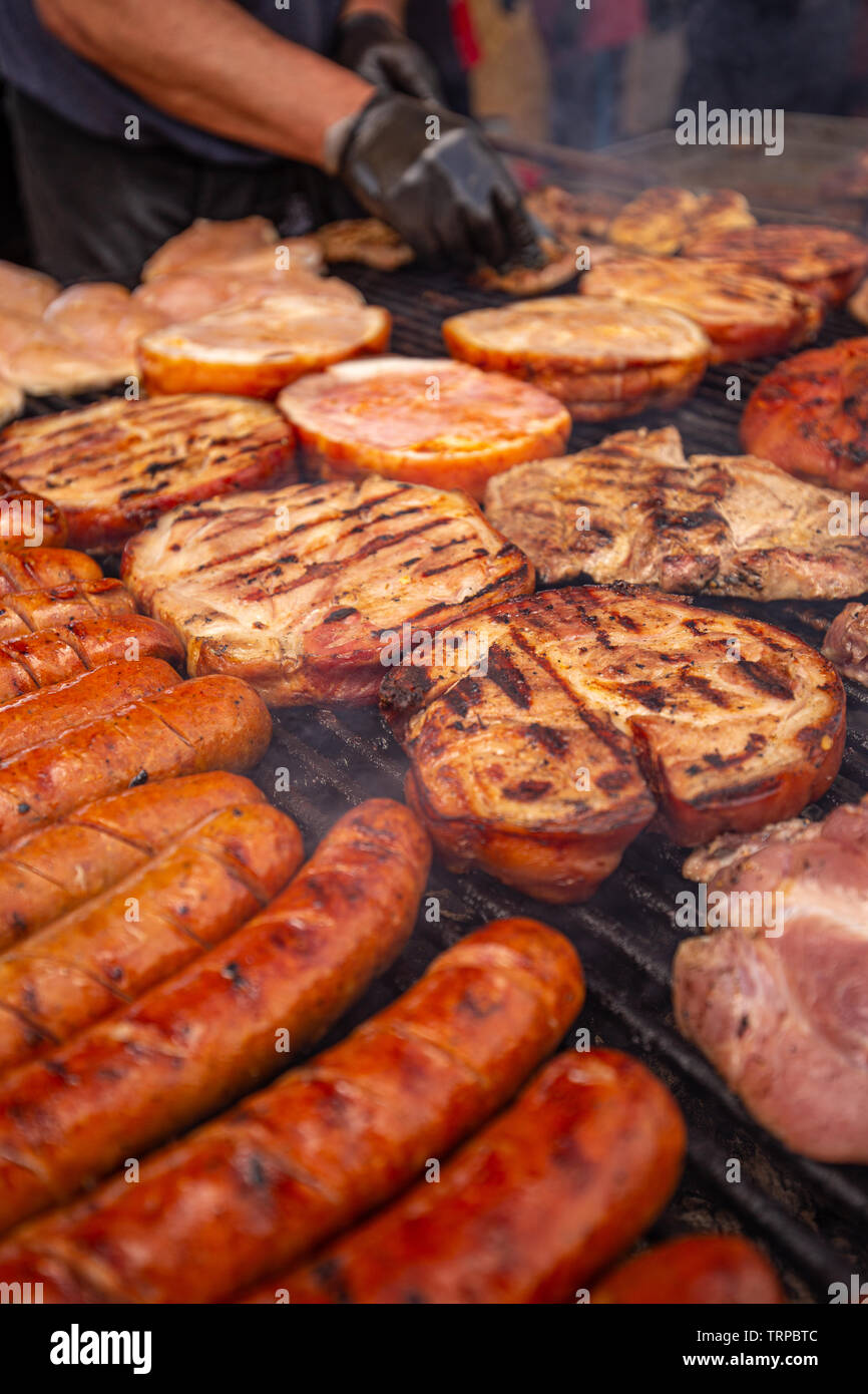 Un assortimento di deliziose grigliate di carne e salsiccia alla brace su un barbecue Foto Stock
