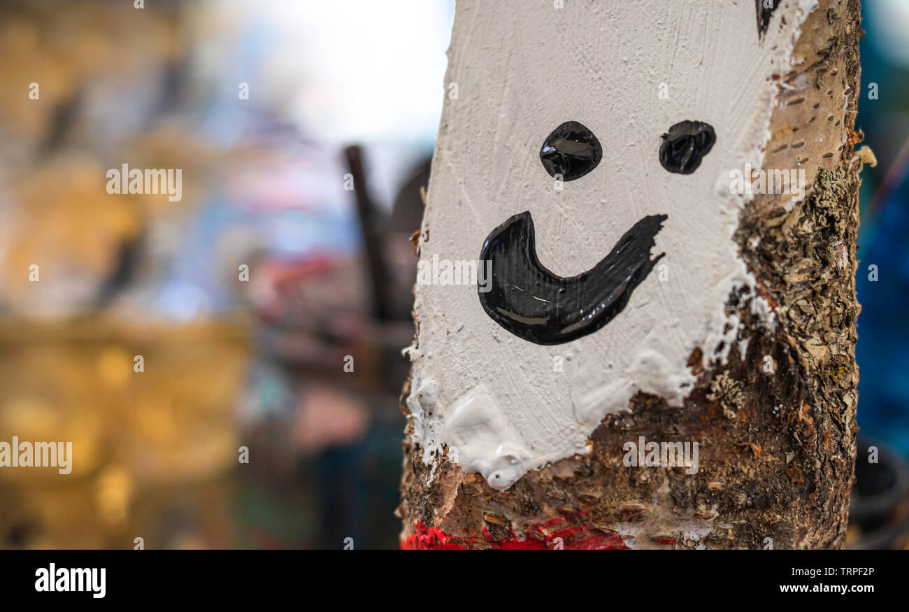 Artigianato divertente volto sorridente dipinto su legno di betulla, della creatività dei bambini Foto Stock