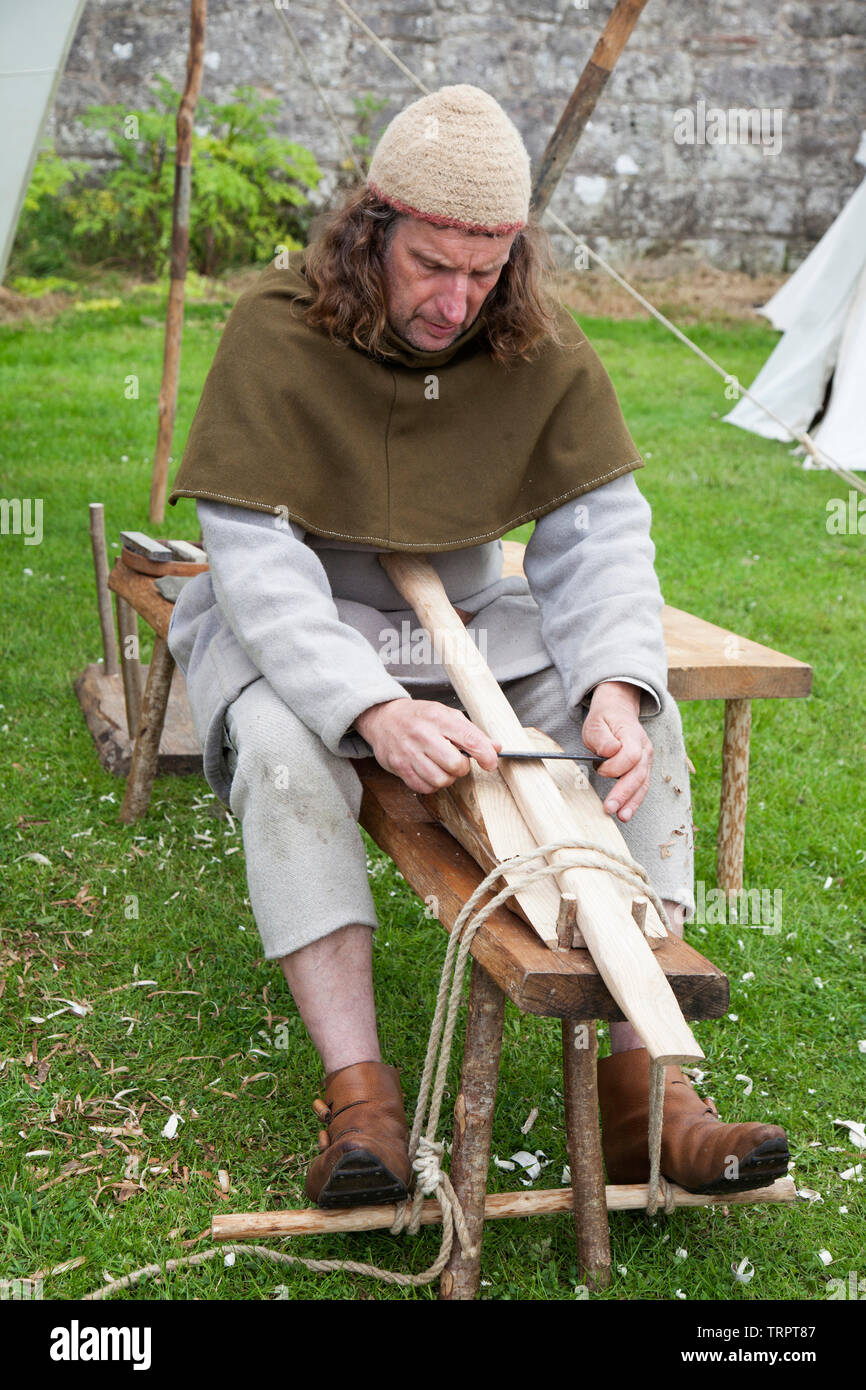 Reenactor del periodo medievale la lavorazione del legno al Rock of Ages festival presso il castello di Dumbarton, Scozia Foto Stock