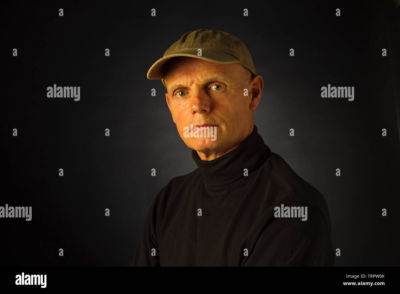 Un ritratto in studio di un uomo che indossa un cappello da baseball Foto Stock
